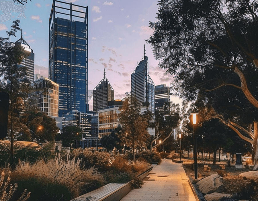 City skyline at sunset with pathway and trees.