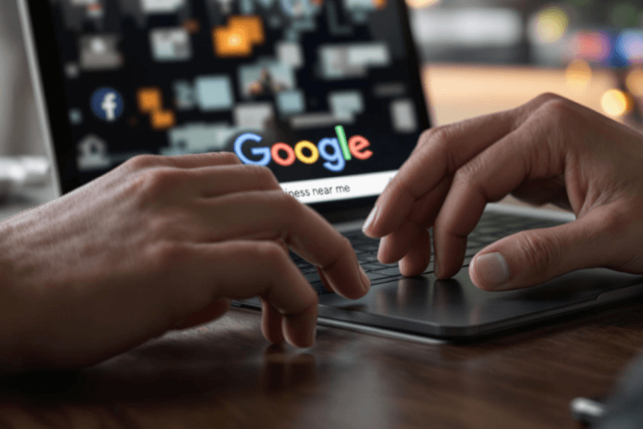 a person using google search and typing business near me inside the search bar