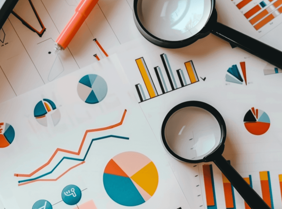 Graphs and charts with magnifying glass and pen.
