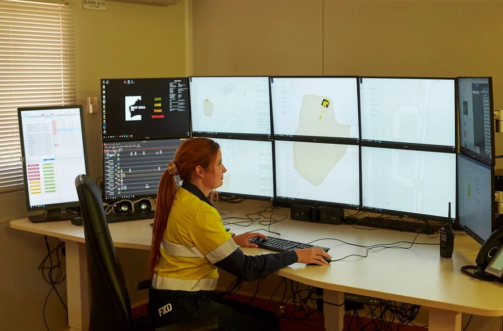 Engineer analyzing CAD designs on multiple monitors