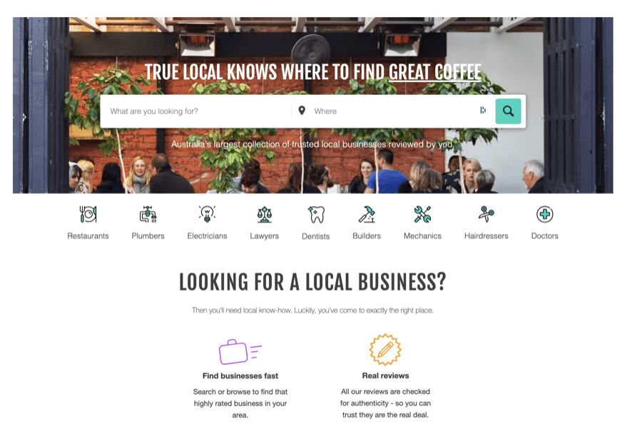 People mingling at a cafe under True Local sign.